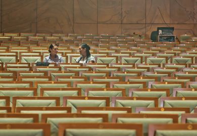 Female students chatting in empty lecture hall