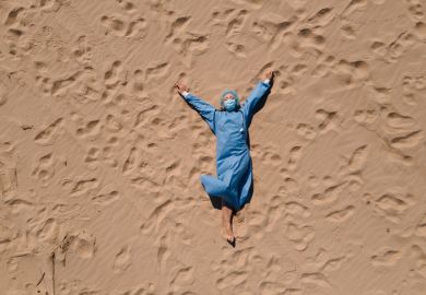 female doctor in medical gear lying on sandy beach