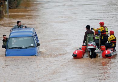 Firemen rescuing men in sinking van, Gloucester, England, 2012