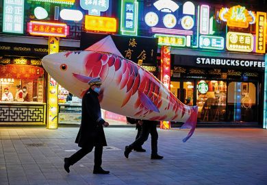Security guards wearing face masks carry a giant fish balloon, illustrating the ballooning of research funding in China Security guards wearing face masks carry a giant balloon in the shape of a fish in Shanghai