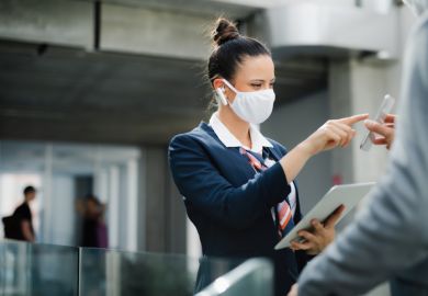 flight attendant talking to businessman on airport, wearing face mask