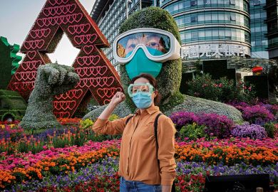 A woman poses in front of a flower display dedicated to healthcare workers during the Covid-19 pandemic A woman poses in front of a flower display dedicated to healthcare workers during the Covid-19 pandemic