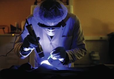 A member of the forensic section of the French gendarmerie (Cellule d’Identification Criminelle, CIC) uses a UV lamp