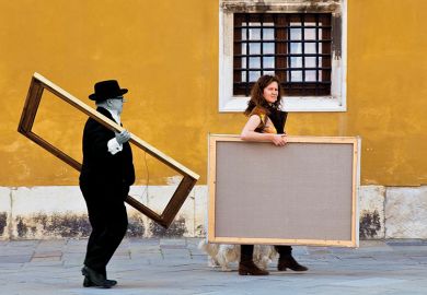 Two people carrying picture frames