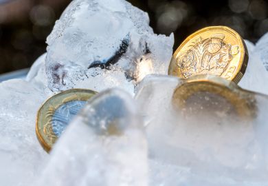 Frozen New British one pound sterling coin up close macro inside ice cubes.
