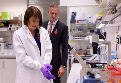 Britain's Chancellor of the Exchequer Rachel Reeves puts on gloves, as she and Britain's Secretary of State for Science, Innovation and Technology Peter Kyle visit the Cambridge Biomedical Campus