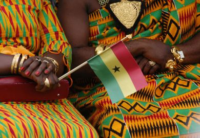 Women in kente dresses with Ghana flag