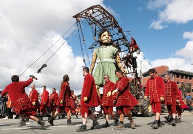 Giant puppet walking through the street