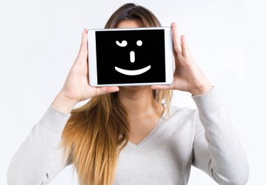 Girl holding a tablet computer with a smiley face on it
