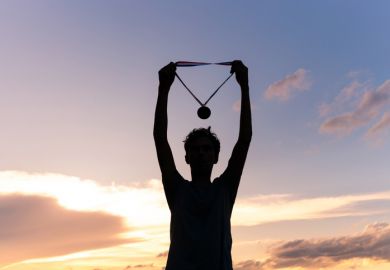 An athlete holds up their medal, illustratiung TEF ratings