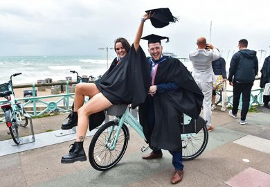 Students celebrate their success on graduating from the University of Brighton on a windy seafront after the ceremony. As an illustration that the public perception of 'graduate regret' is overestimated.