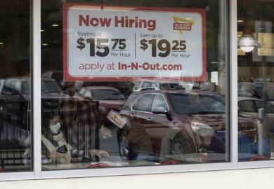 Grants Pass, OR, USA - Mar 19, 2022 Now Hiring sign with promised hourly wage rates is seen at one of the In-N-Out Burger chain restaurants in Grants Pass, Oregon, amidst the labor shortage.