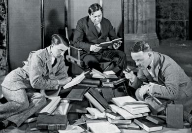 Group of men reading pile of books
