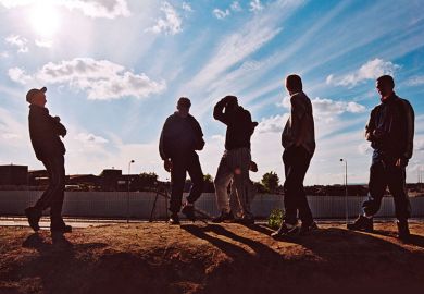 Group of teenage boys hang out on wasteland