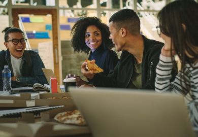 Group of students eating pizza at college canteen