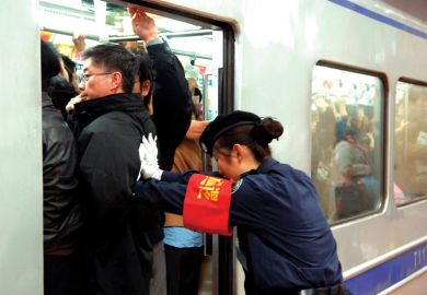 Guard pushes people onto train in Beijing