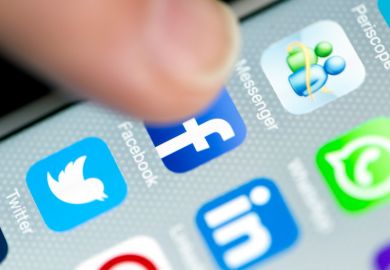 Hand tapping social media icon on smartphone screen