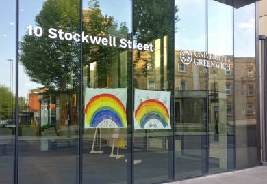 Hand drawn rainbow expressing thank to NHS and key workers displayed at glass window University of Greenwich during coronavirus outbreak
