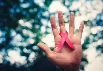 Hand holding AIDS ribbon