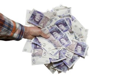 Hand holding £20 notes
