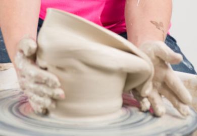 Hands working clay on potter's wheel Hands working clay on potter's wheel