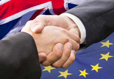 Handshake in front of European Union and United Kingdom flags Handshake in front of European Union and United Kingdom flags