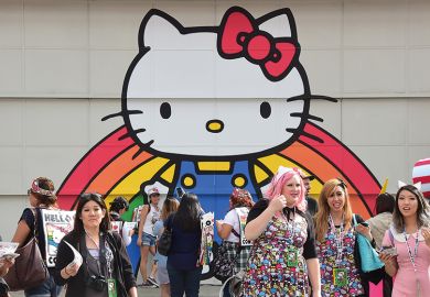 Hello Kitty mural with people in a group of people in front of it