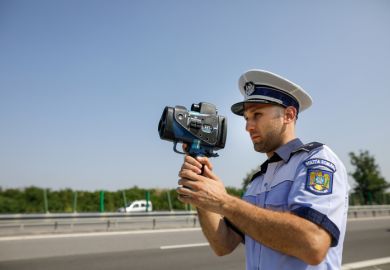 Highway 2 Bucharest - Constanta, Romania - 10 August, 2021 Romanian Road Police officer uses a radar speed gun.