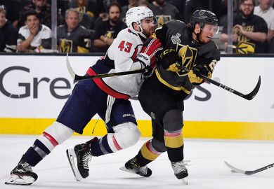 two ice hockey players in tackle two ice hockey players in tackle