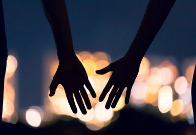 Two hands reach for each other, symbolising teaching and learning