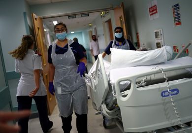 Medical staff transfer a patient through a corridor at The Royal Blackburn Teaching Hospital in East Lancashire. To illustrate that the UK’s incoming tax on international student fees could have unintended consequences for country’s health system.
