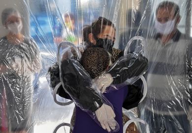 People hugging through PPE