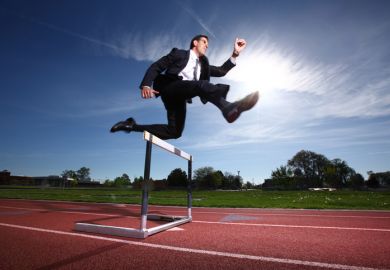 Businessman jumping a hurdle