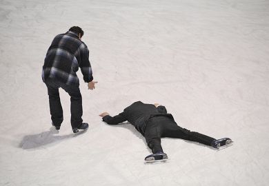 Man helps fellow skater who has fallen on the ice