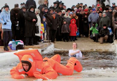 A rescue worker exits the icy waters of the Dnepr River in Kiev during an Orthodox Epiphany celebration