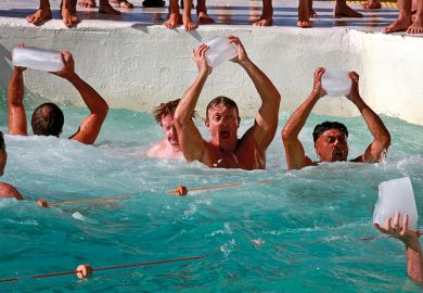 Swimmers holding ice cubes aloft