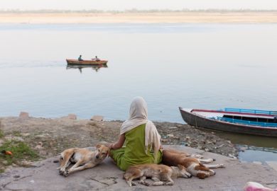 Indian woman meditating Scarfed young indian woman meditating on the border of the Ganges