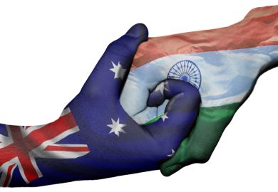 Hands with Australian and Indian flags locked together