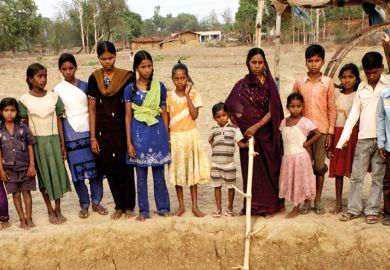 Indian women and children standing beside well Indian women and children standing beside well