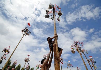 Participants climb greasy poles to collect prizes during celebrations for Indonesia’s 78th Independence Day in Jakarta, 17 August 2023