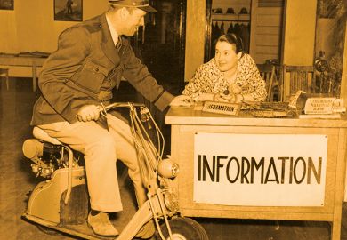 Man on scooter talks to woman at information desk Man on scooter talks to woman at information desk