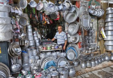 Iranian market trader with a large number of cooking pots, symbolising citations