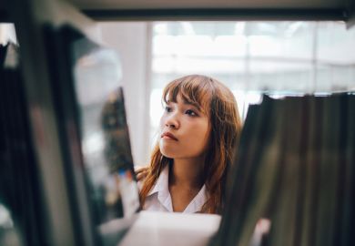 Woman searching books in library 