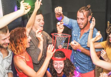 Students play a drinking game. Pushing the uni experience could backfire on the university sector as students push for fee refunds