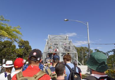 Race day at Melbourne's Motor Show. Spectators make their way safely over the footbridge to Albert Park.
