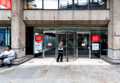 King's College red sign and entrance on Strand Campus Macadam Building with people entering