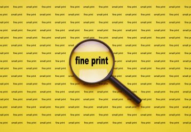 Fine print enlarged with magnifying glass Fine print enlarged with magnifying glass illustrating that academics should read and understand publishing contracts