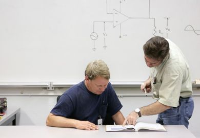 Mature student being shown text by teacher