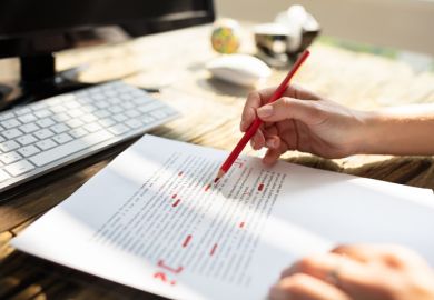 Person marking an error on a page with red marker