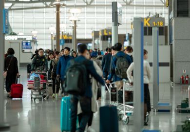 People with suitcases and luggage carts at Incheon International Airport. 